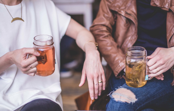 Two people drinking mugs of hot tea