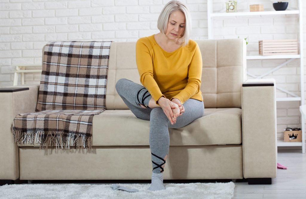 Woman rubbing sore foot