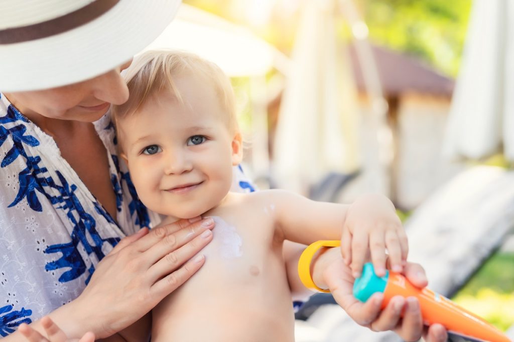 Woman applying sunscreen on a baby
