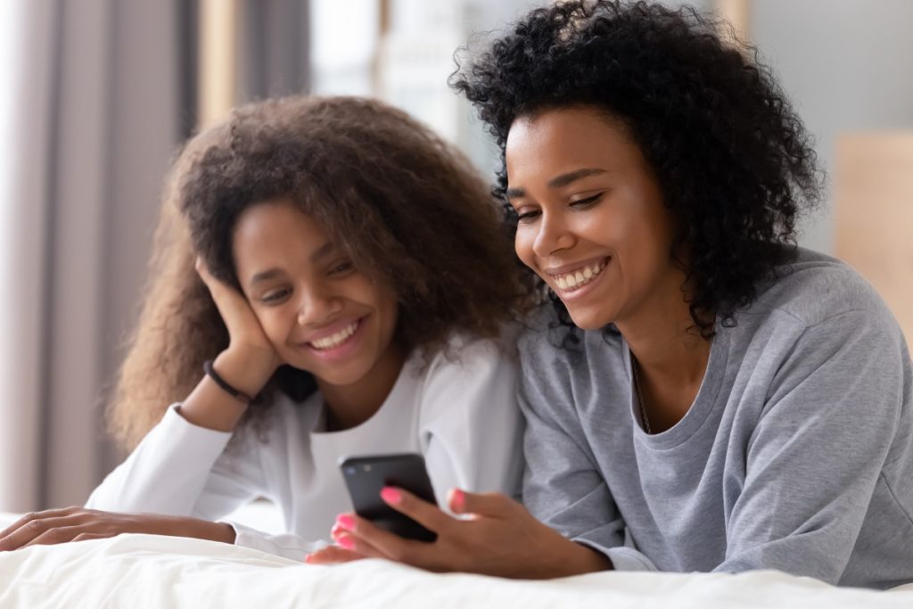 Mother and teenage daughter looking at phone