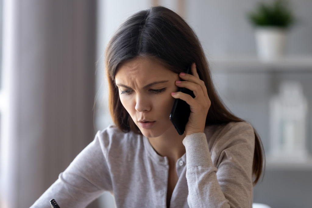 Woman talking on cell phone with concerning look